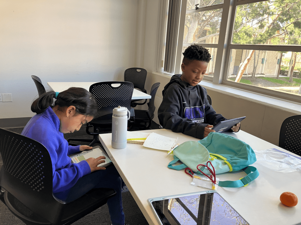 2 Students working on their coding programs